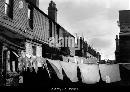 Lavarsi appesi nei cortili posteriori di una strada di case a schiera vittoriane durante l'eliminazione dei baraccopoli e la demolizione di St Ann's, Nottingham. 1969-1972 Foto Stock