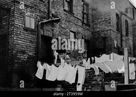 Linee di lavaggio appese nei cortili posteriori di una strada case a schiera vittoriane durante la demolizione di St Ann's, Nottingham. 1969-1972 Foto Stock