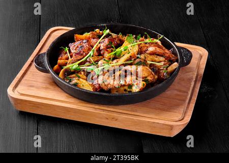 Mandrino di maiale arrosto con funghi, patate, cipolle e verdure in padella Foto Stock