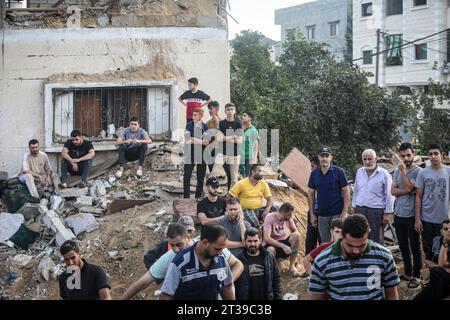 Khan Yunis, territori palestinesi. 24 ottobre 2023. I palestinesi stanno intorno a un cratere causato da uno sciopero israeliano a Khan Yunis. Credito: Mohammed Talatene/dpa/Alamy Live News Foto Stock