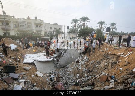 Khan Yunis, territori palestinesi. 24 ottobre 2023. I palestinesi stanno intorno a un cratere causato da uno sciopero israeliano a Khan Yunis. Credito: Mohammed Talatene/dpa/Alamy Live News Foto Stock