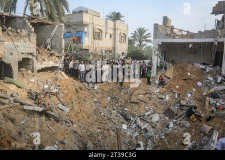 Khan Yunis, territori palestinesi. 24 ottobre 2023. I palestinesi stanno intorno a un cratere causato da uno sciopero israeliano a Khan Yunis. Credito: Mohammed Talatene/dpa/Alamy Live News Foto Stock