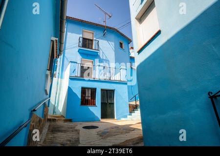Dal basso di vecchie case residenziali in pietra con balconi e scale situate in città contro il cielo blu alla luce del sole all'ingresso dell'edificio W. Foto Stock