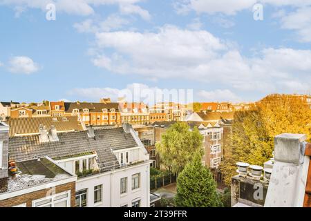 Vista aerea del paesaggio urbano con edifici residenziali e alberi contro il cielo nuvoloso durante l'estate Foto Stock