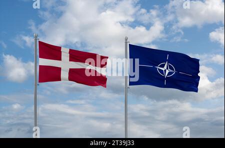 Le bandiere NATO e Danimarca sventolano insieme su un cielo nuvoloso blu, concetto di cooperazione Foto Stock