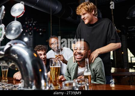 uomo che tocca le spalle di felice sposo afroamericano durante la festa di scapolo, amicizia maschile Foto Stock