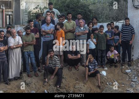 Khan Yunis, territori palestinesi. 24 ottobre 2023. I palestinesi stanno intorno a un cratere causato da uno sciopero israeliano a Khan Yunis. Credito: Mohammed Talatene/dpa/Alamy Live News Foto Stock