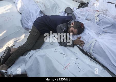 Khan Yunis, territori palestinesi. 24 ottobre 2023. Un palestinese piange accanto ai corpi dei membri della famiglia Saqallah, che sono stati uccisi in un attacco aereo israeliano. Credito: Mohammed Talatene/dpa/Alamy Live News Foto Stock