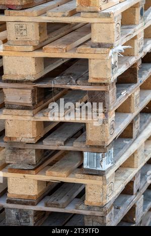 astrazione di pallet per carrelli elevatori in legno impilati in un cumulo pronto per il riciclaggio o il riutilizzo. Foto Stock