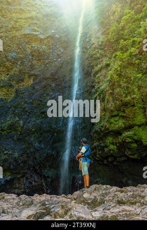 Sonnenuntergang, ein Vater mit seinem Sohn am Wasserfall a Levada do Caldeirao Verde, Queimadas, Madeira Foto Stock