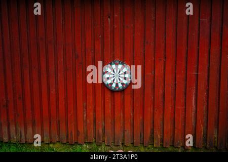 Tavola DART appesa a una parete di legno rossa Foto Stock