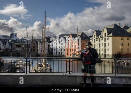 EN la ciudad de Alesund, turista contemplando la vista del Canal, barcos y edificios art noveau, Noruega Foto Stock