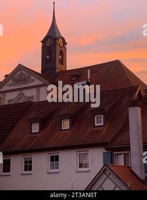 Un grande edificio bianco con una grande torre dell'orologio che si innalza sopra di esso, illuminato sullo sfondo di un cielo blu cristallino Foto Stock