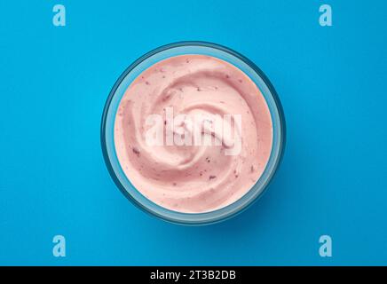 Yogurt a bacca su sfondo blu, vista dall'alto Foto Stock