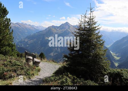 una panchina di legno sulle montagne invita gli escursionisti a fare una pausa Foto Stock