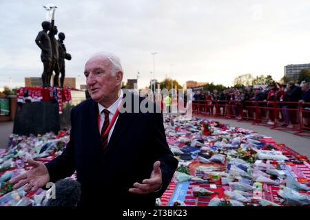 L'ex giocatore del Manchester United Alex Stepney visita i tributi in memoria di Sir Bobby Charlton che si trovano fuori dallo stadio, dopo la sua morte all'età di 86 anni, davanti alla partita di UEFA Champions League tra Manchester United e FC Copenhagen all'Old Trafford, Manchester. Charlton è stato un membro chiave della squadra inglese vittoriosa Coppa del mondo 1966 e ha anche goduto di un grande successo a livello di club con lo United, che è diventato il primo club inglese a vincere la Coppa Europa nel 1968. Data immagine: Martedì 24 ottobre 2023. Foto Stock