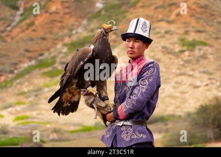 Cacciatore del Kirghizistan con Aquila reale addestrata (Aquila chrysaetos), lago Song kol, regione di Naryn, Kirghizistan Foto Stock