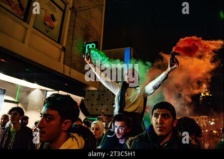 Nijmegen, Paesi Bassi. 23 ottobre 2023. Un manifestante è visto in possesso di bombe fumogene verdi e rosse durante la manifestazione. Circa 800 manifestanti hanno camminato per il centro della città per condannare il governo di Israele ed esprimere la loro solidarietà al popolo palestinese. Questa manifestazione pro palestinese è stata una delle più grandi manifestazioni organizzate in città. (Foto di Ana Fernandez/SOPA Images/Sipa USA) credito: SIPA USA/Alamy Live News Foto Stock