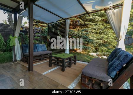 Posa di piastrelle per terrazze in un gazebo su un terreno ricreativo in estate Foto Stock