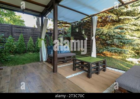 Posa di piastrelle per terrazze in un gazebo su un terreno ricreativo in estate Foto Stock