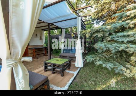 Posa di piastrelle per terrazze in un gazebo su un terreno ricreativo in estate Foto Stock