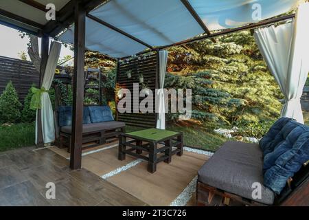 Posa di piastrelle per terrazze in un gazebo su un terreno ricreativo in estate Foto Stock