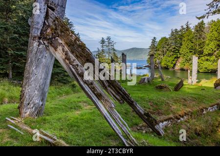 Resti di case lunghe e pali totemici presso Sgang Gwaay Llnagaay, sito patrimonio dell'umanità dell'UNESCO, un antico villaggio della riserva del Parco Nazionale di Gwaii Haanas Foto Stock