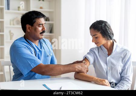 Vaccinazione antivirale. Lavoratore medico di mezza età che attacca la benda in gesso sulla spalla del paziente Foto Stock