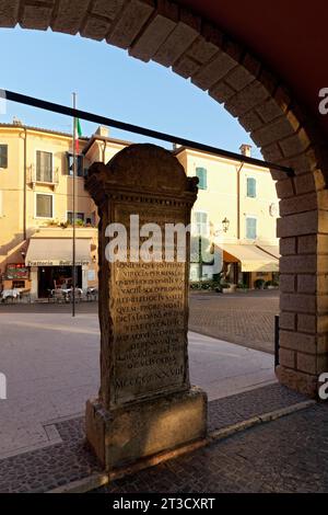 Pietra commemorativa del traduttore Domizio Calderini, iscrizione latina, data 1478, vista attraverso i portici, Piazza Calderini, torri del Benaco, lago Foto Stock