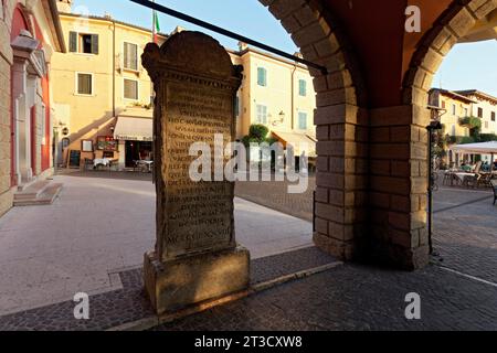 Pietra commemorativa del traduttore Domizio Calderini, iscrizione latina, data 1478, vista attraverso i portici, Piazza Calderini, torri del Benaco, lago Foto Stock