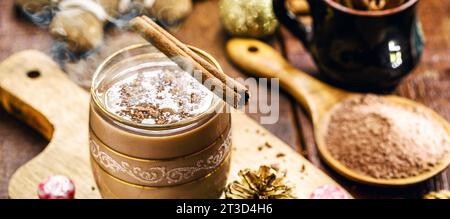 Coppa di Natale decorata con cioccolata calda, bastone di cannella, cacao e pan di zenzero uomo sullo sfondo Foto Stock