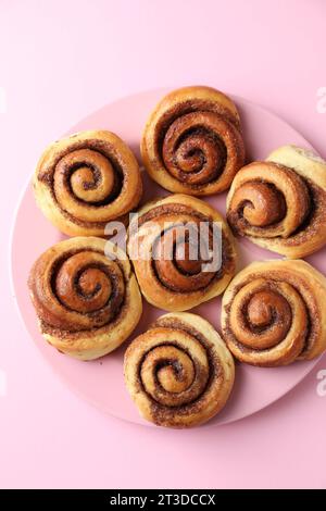 Molti gustosi dolci alla cannella, sfondo rosa, vista dall'alto Foto Stock