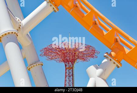 Paracadutisti ormai lontani, la torre Parachute Jump domina ancora lo skyline di Coney Island. Il vivace simbolo rosso è illuminato di notte. Foto Stock