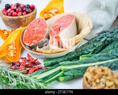 Coloratissima gamma di ingredienti vegetali autunnali con bistecche di salmone di salsiccia per un'alimentazione sana o senza carne, ringraziamento con pesce. Foto Stock