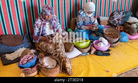 Valle di Ourika, Marocco - 16 settembre 2022: Le donne lavorano in una cooperativa per produrre frutti di argan. Usano piccole pietre per rompere la frutta aperta Foto Stock