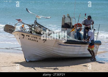 Portogallo, Algarve, Armacao de Pera: Catture del giorno. Barca da pesca sulla spiaggia Foto Stock