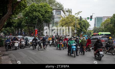 Traffico caos ad Hanoi, Vietnam, come moto e automobili competere per lo spazio in un incrocio occupato. Foto Stock