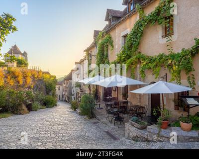 St Cirq Lapopie, Lot, Francia. Vista sulla strada del villaggio e del ristorante che guarda verso la chiesa. Foto Stock