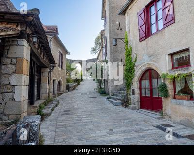 St Cirq Lapopie, Lot, Francia. Vista sulla strada con ciottoli che guarda verso il cancello orientale. Foto Stock