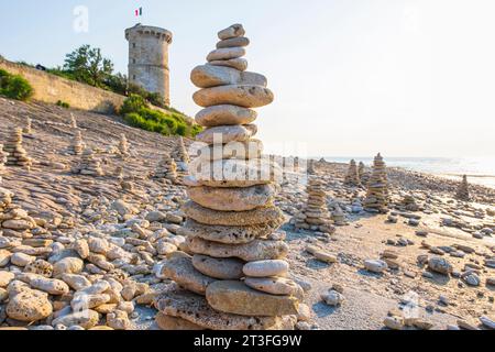 Francia, Charente Maritime, Ile de Re, Saint Clement des Baleines, cairns sulla spiaggia ai piedi del vecchio faro Baleines o della torre Vauban (XVII secolo) Foto Stock