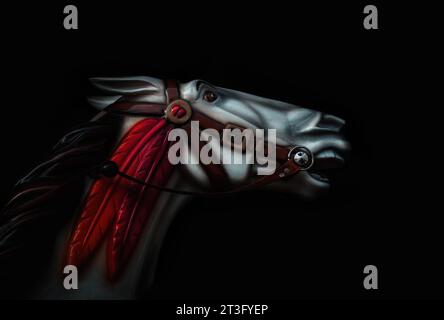 Ritratto a basso profilo di un cavallo a carosello retrò. Cavallo rotondo d'epoca generico da un giro in fiera, su sfondo nero. Foto Stock