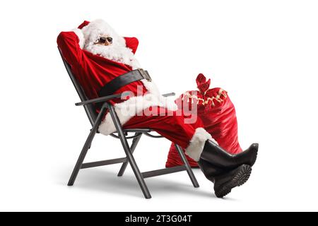 Babbo natale indossa occhiali da sole e si diverte in una sedia pieghevole isolata su sfondo bianco Foto Stock