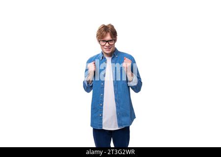 giovane bell'uomo caucasico con i capelli rossi corti vestito con una camicia blu su sfondo bianco con spazio per la copia Foto Stock