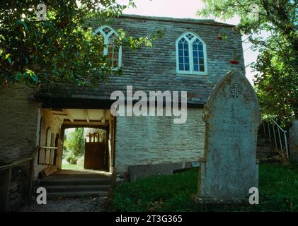 Vista a W del lychgate con la sala superiore della chiesa di St Clement, St Clement, Cornovaglia, Inghilterra, Regno Unito, preso nell'ottobre 1990 prima del restauro 2004-2008. Foto Stock