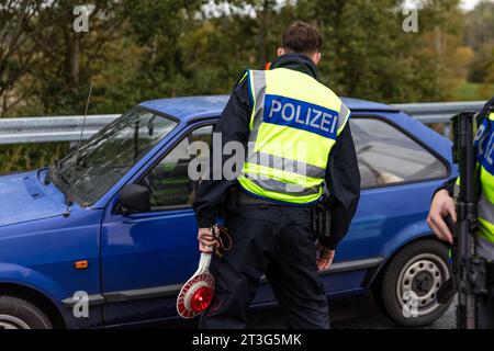 Bademeusel, Germania. 24 ottobre 2023. Un agente di polizia federale parla con il conducente di un'auto sulla superstrada A15, al confine tra Polonia e Germania. Dal 16 ottobre sono stati effettuati controlli temporanei stazionari alle frontiere interne per le frontiere con Polonia, Repubblica ceca e Svizzera. (Al dpa "il ministro degli interni Stübgen critica la natura temporanea dei controlli alle frontiere”) credito: Frank Hammerschmidt/dpa/Alamy Live News Foto Stock