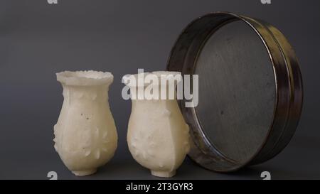 Stagione dei festival indiani, zucchero bianco karwa o karva con chalni isolati su sfondo grigio. Foto Stock