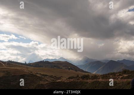 Fine della giornata vicino a Maras in Perù. Il tempo nuvoloso e il sole che sbircia tra le nuvole creano un paesaggio spettacolare. Foto Stock