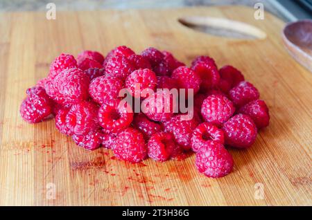 Lamponi rossi su una tavola di legno pronti per preparare la marmellata Foto Stock