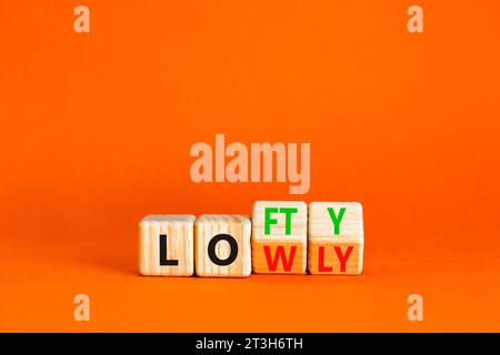 Simbolo alto o basso. Parole concettuali Lofty lowly su blocco di legno. Bellissimo sfondo arancione. Concetto di business alto o basso. Copia spac Foto Stock