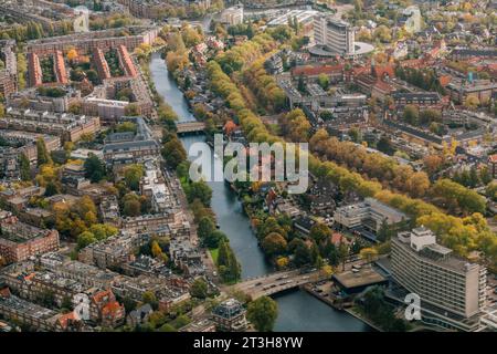 Una vista aerea di un canale che scorre attraverso Amsterdam, Paesi Bassi, in un pomeriggio autunnale Foto Stock